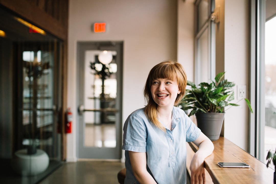 A woman standing confidently with a smile, showcasing self-assurance and comfort in her own skin.
