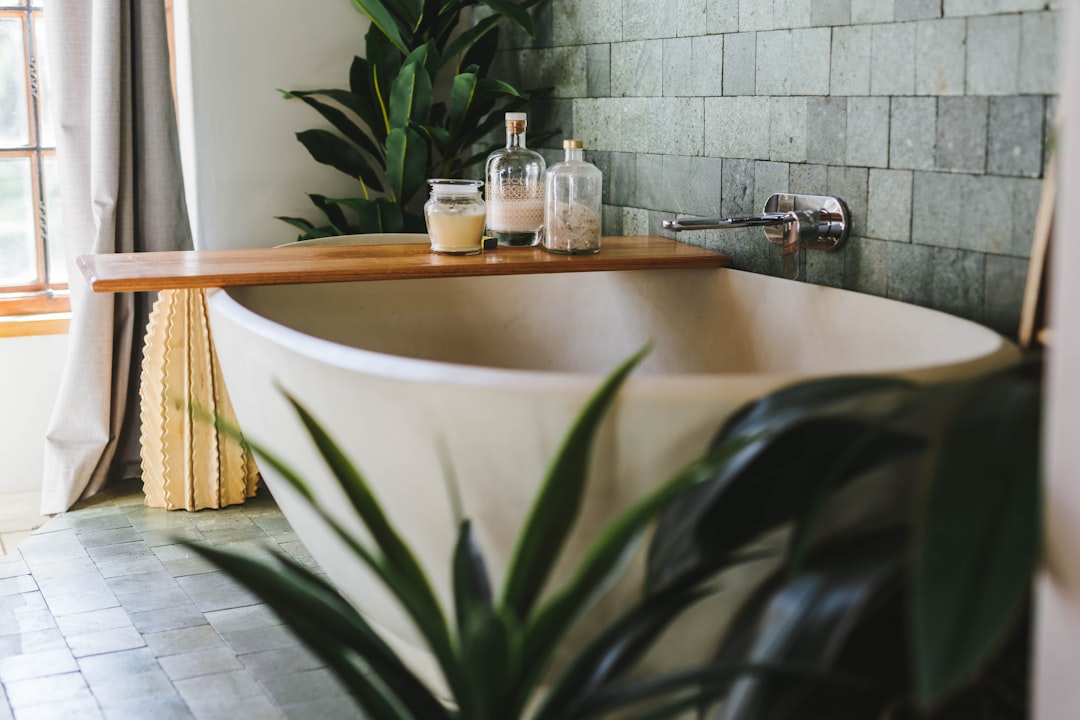 A serene bathroom setting with soft lighting, candles, and natural elements, creating a calming spa atmosphere.