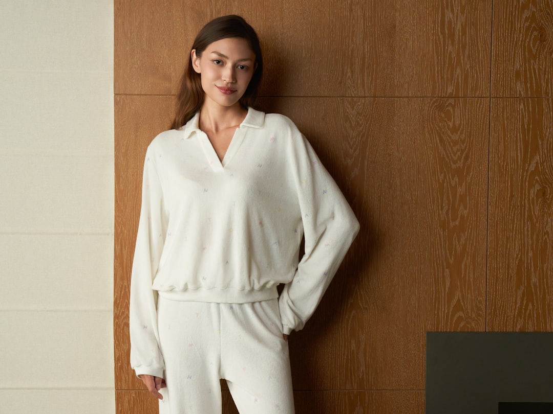 A person wearing cozy and stylish home attire, sitting comfortably in a bright living room, exuding confidence and relaxation.