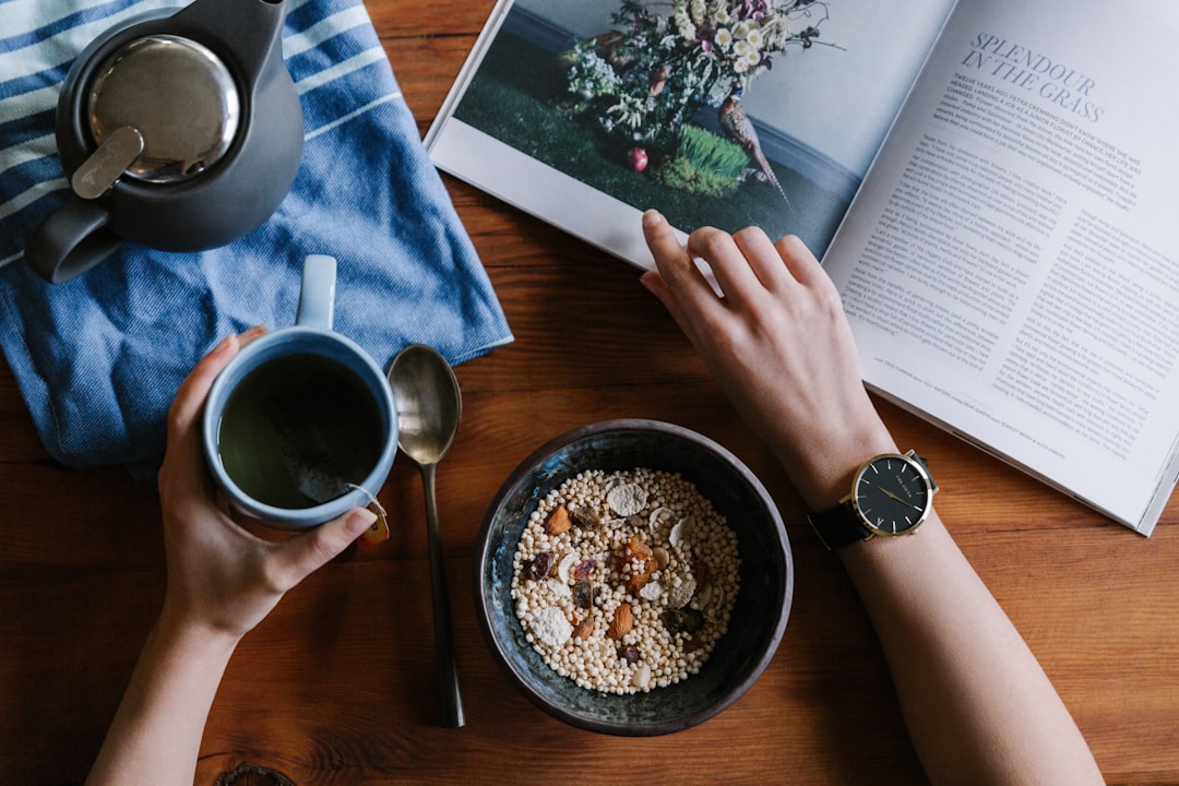 A serene morning routine scene with a cup of tea, a journal, and a plant on a wooden table, symbolizing mindfulness and well-being.